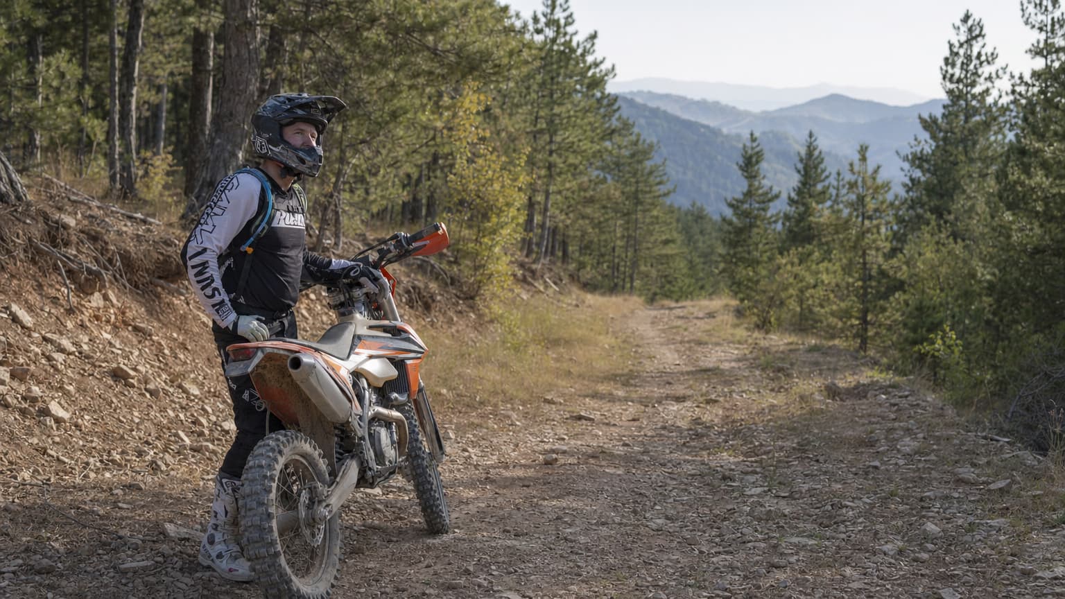 Beginner enduro rider getting briefing in front of a KTM 350 in the North Macedonian mountains
